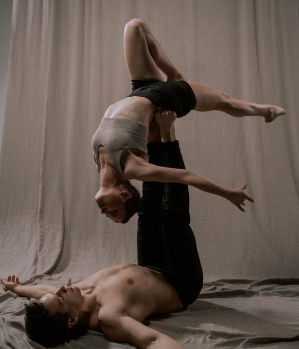 Couple performing a partner yoga pose in a calm setting.